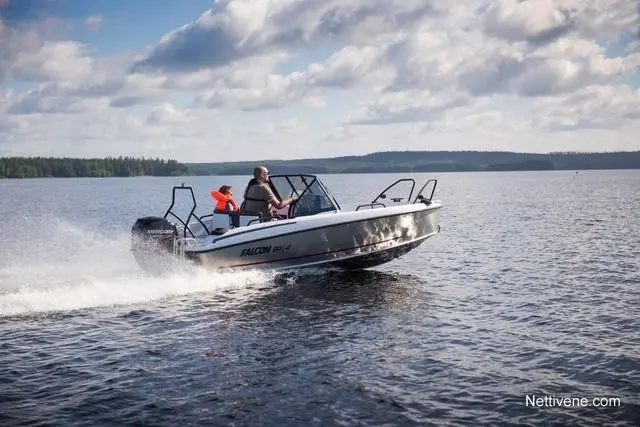 A speedboat named "FALCON" skims across a lake, with two people onboard enjoying a sunny day on the water.